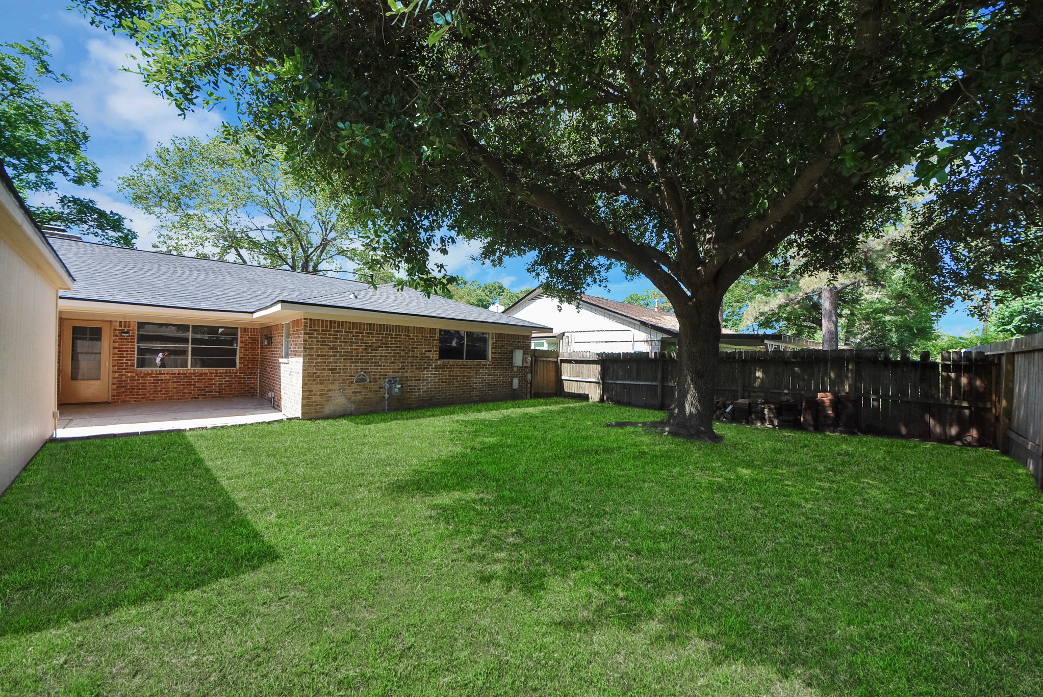2402 Rolling Glen Drive Spring, TX 77373 - Photo 34 of 38 a view of a backyard with table and chairs and a large tree