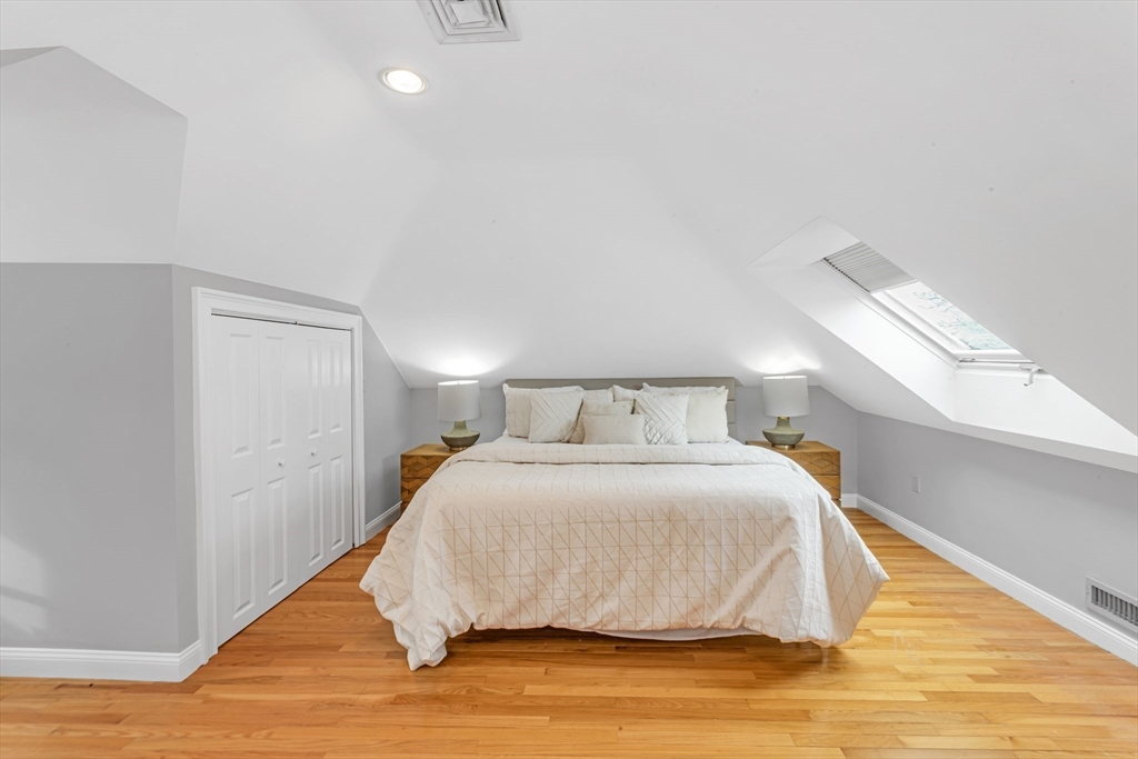 231 Lagrange Street Boston, MA 02132 - Photo 34 of 42 a bedroom with a bed and wooden floor