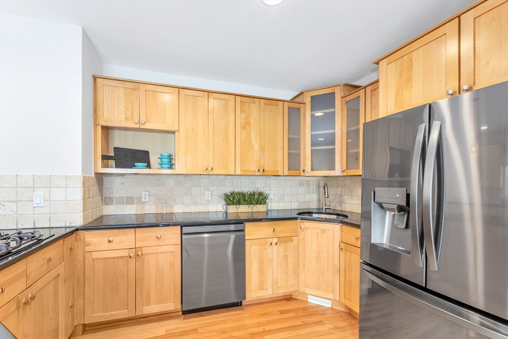 231 Lagrange Street Boston, MA 02132 - Photo 10 of 42 a kitchen with stainless steel appliances granite countertop a refrigerator and a sink
