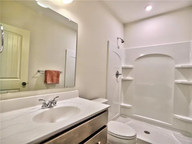 a bathroom with a sink a toilet and shower