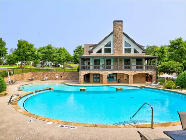 a front view of house with yard and swimming pool