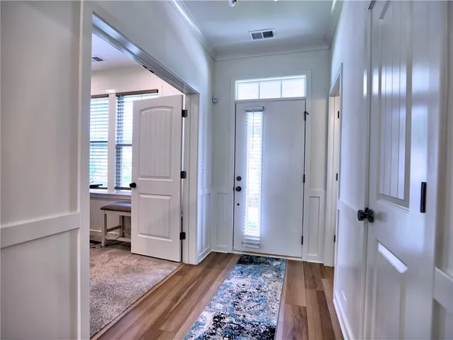 a view of a hallway with wooden floor and staircase