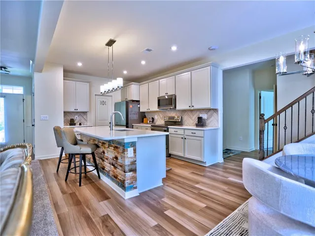 a kitchen with a table chairs microwave and cabinets