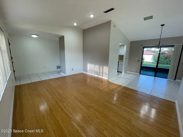 a view of empty room with wooden floor