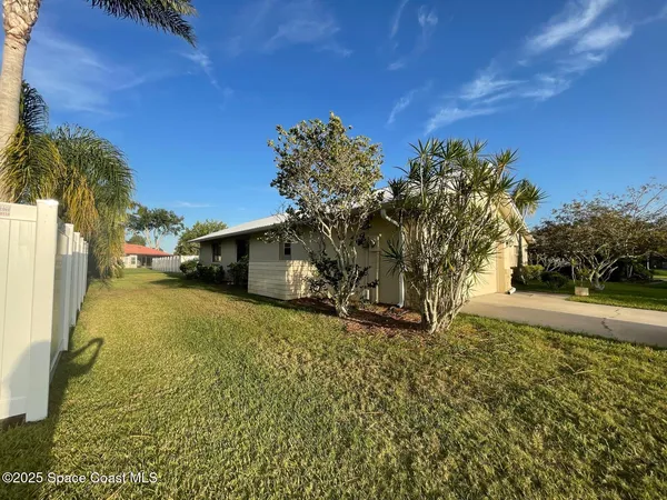 a view of a yard with wooden fence
