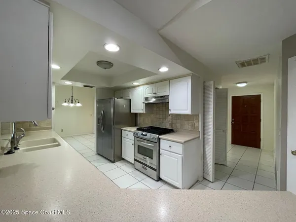 a kitchen with stainless steel appliances granite countertop a sink and a refrigerator