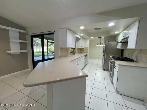 a kitchen with stainless steel appliances a refrigerator sink and microwave