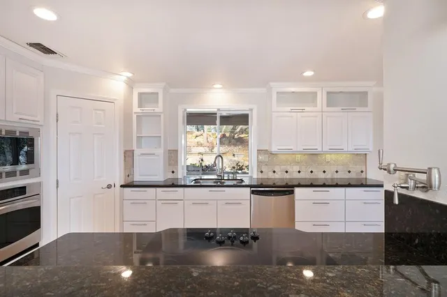 a bedroom with a large bed a flat screen tv and a large window