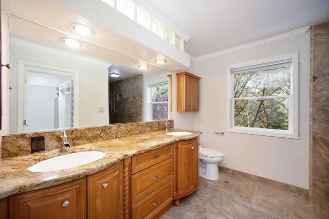 a bathroom with a granite countertop sink mirror and bathtub