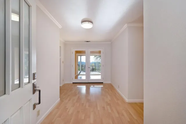 a view of a hallway with wooden floor and a bathroom