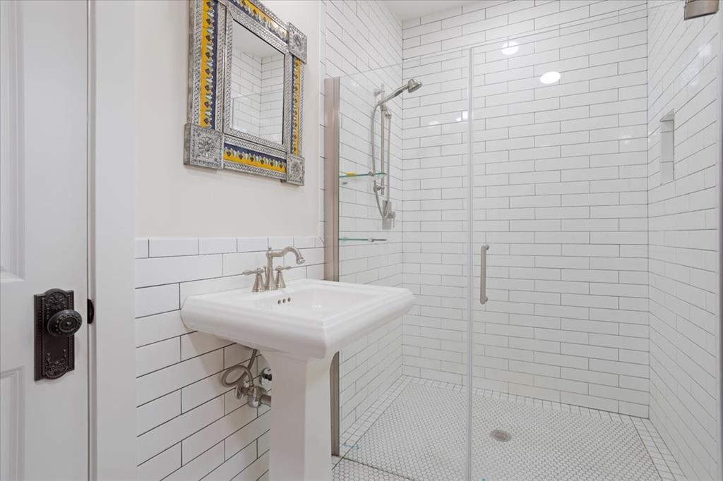 300 West 6th Street Bonham, TX 75418 - Photo 22 of 37 a bathroom with a sink a mirror and shower