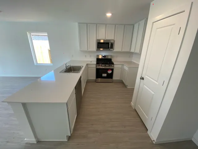 a kitchen with white cabinets and stainless steel appliances
