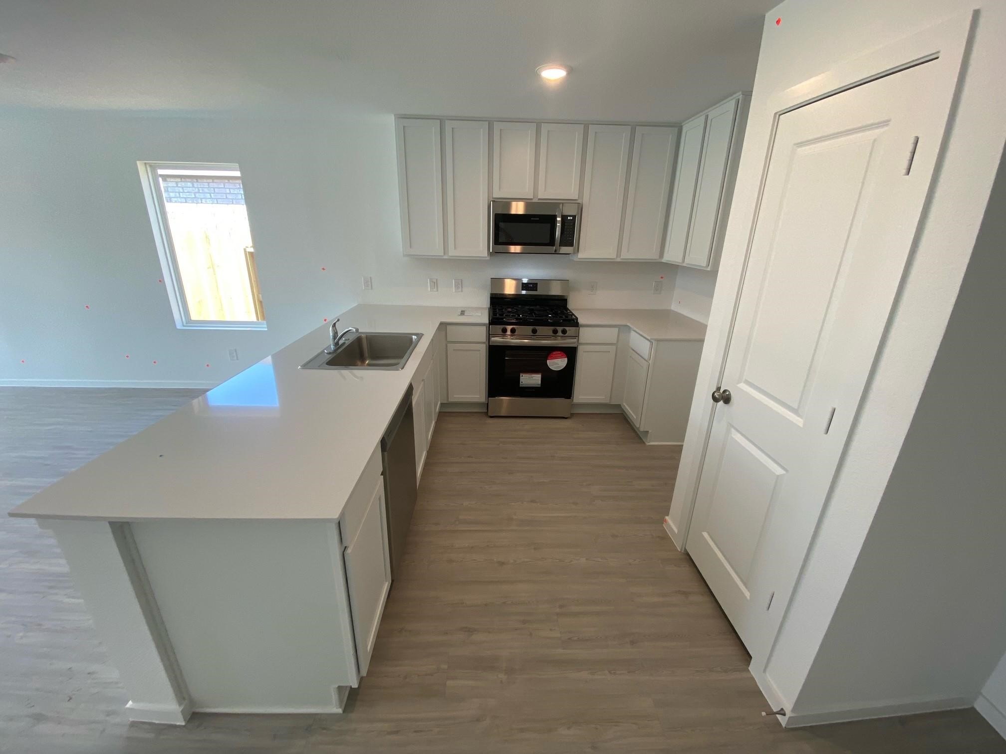 3611 Atlas Pt Lane Angleton, TX 77515 - Photo 3 of 27 a kitchen with white cabinets and stainless steel appliances