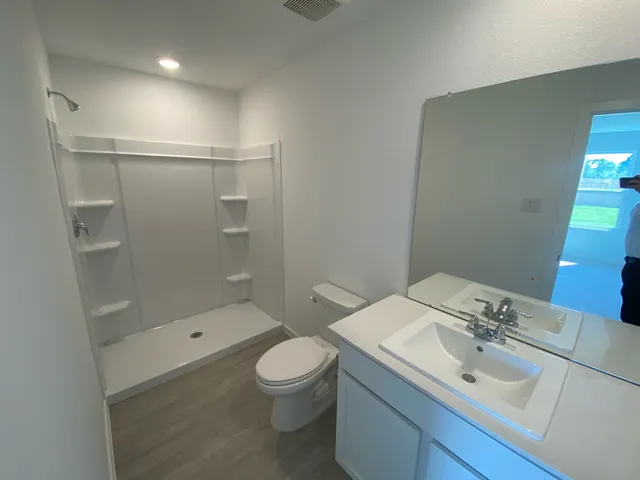 a bathroom with a sink and mirror with toilet