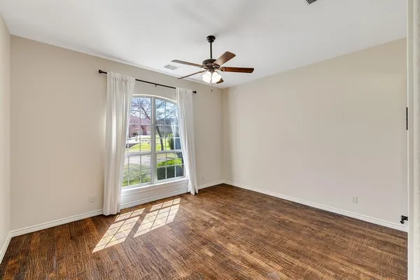 wooden floor in an empty room with a window