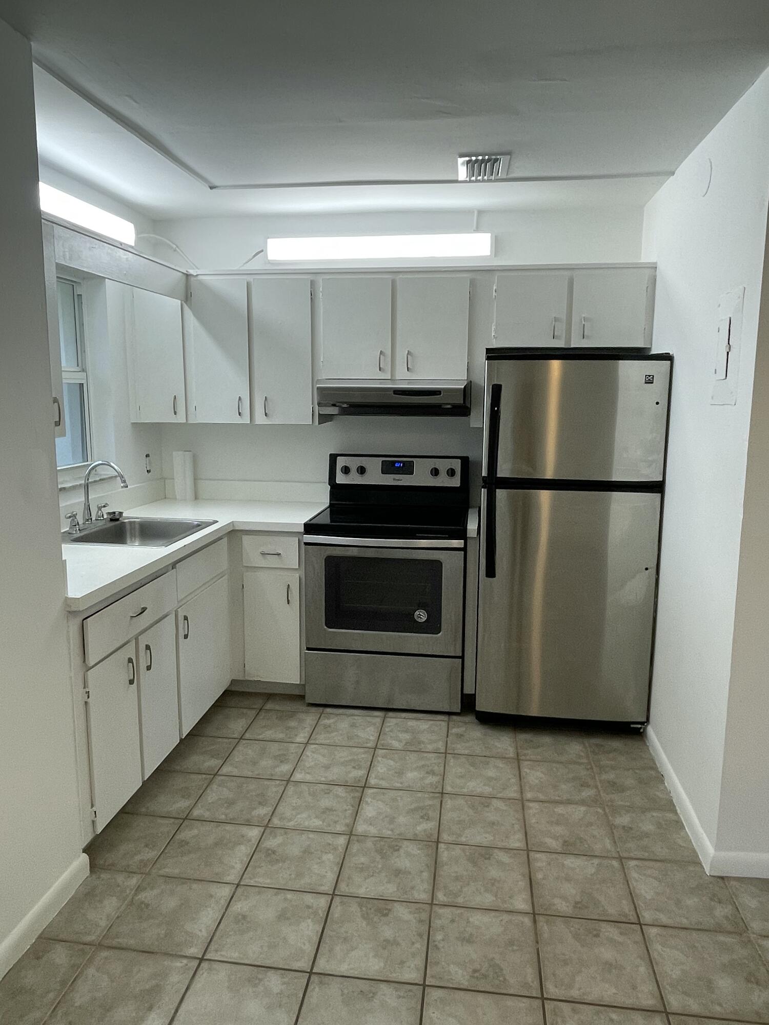 12058 Ellison Wilson Road North Palm Beach, FL 33408 - Photo 2 of 13 a kitchen with a stove a refrigerator and a sink