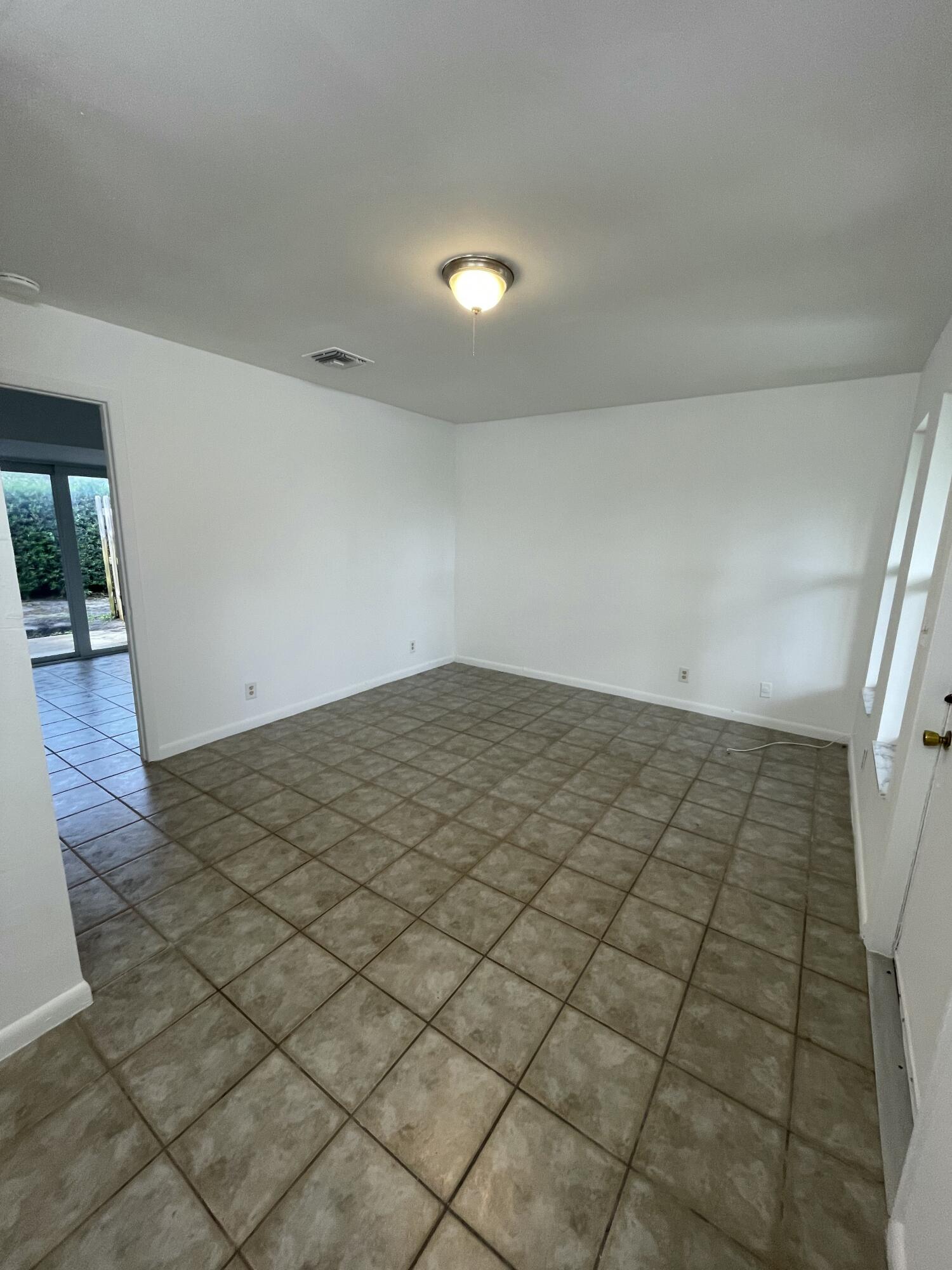 12058 Ellison Wilson Road North Palm Beach, FL 33408 - Photo 3 of 13 an empty room with white walls and tiles