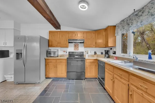 a kitchen with stainless steel appliances a refrigerator and a stove top oven