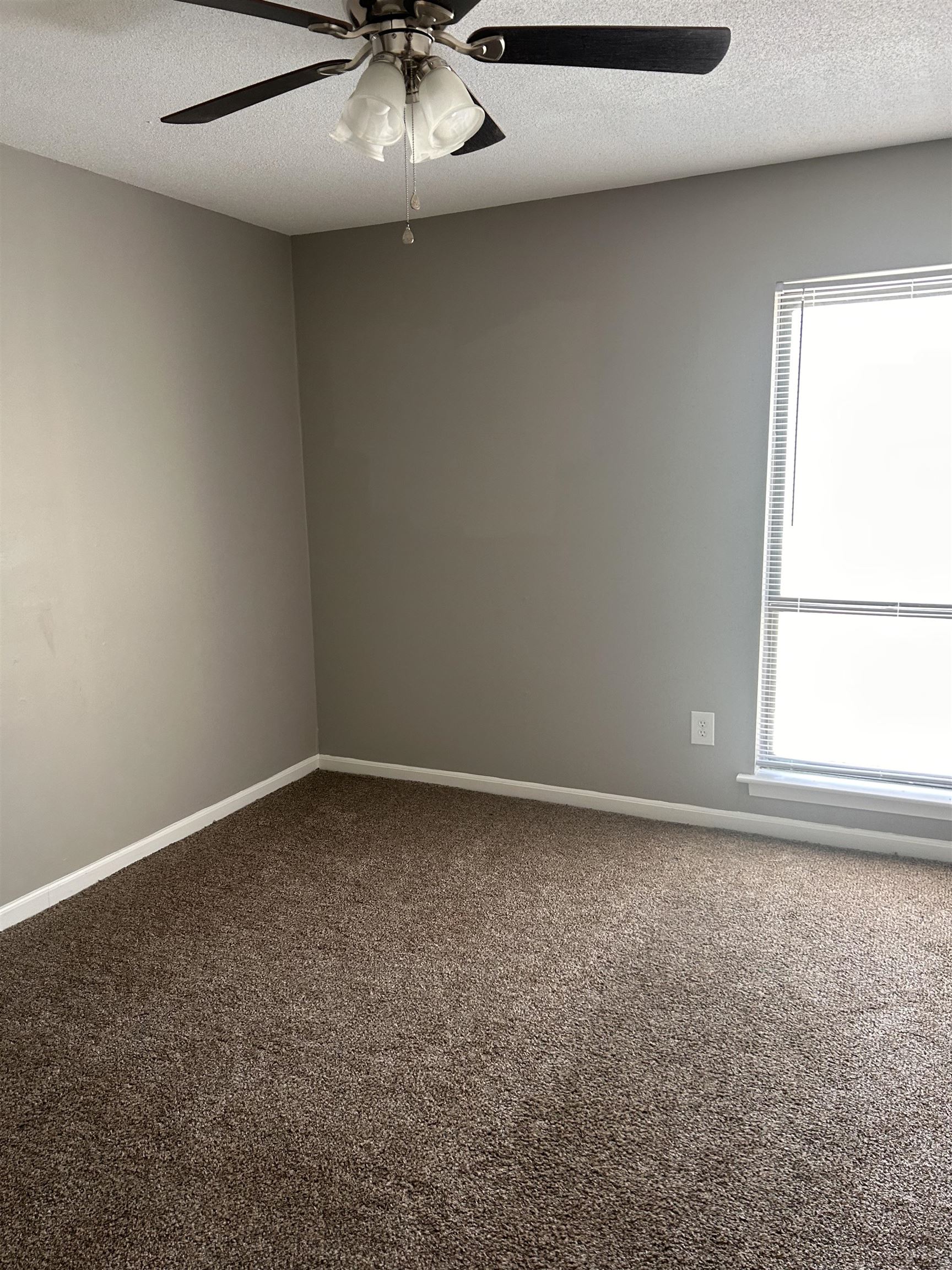 1772 6th Crompton Square, Unit B Memphis, TN 38134 - Photo 7 of 8 Empty room featuring a textured ceiling, ceiling fan, and dark colored carpet