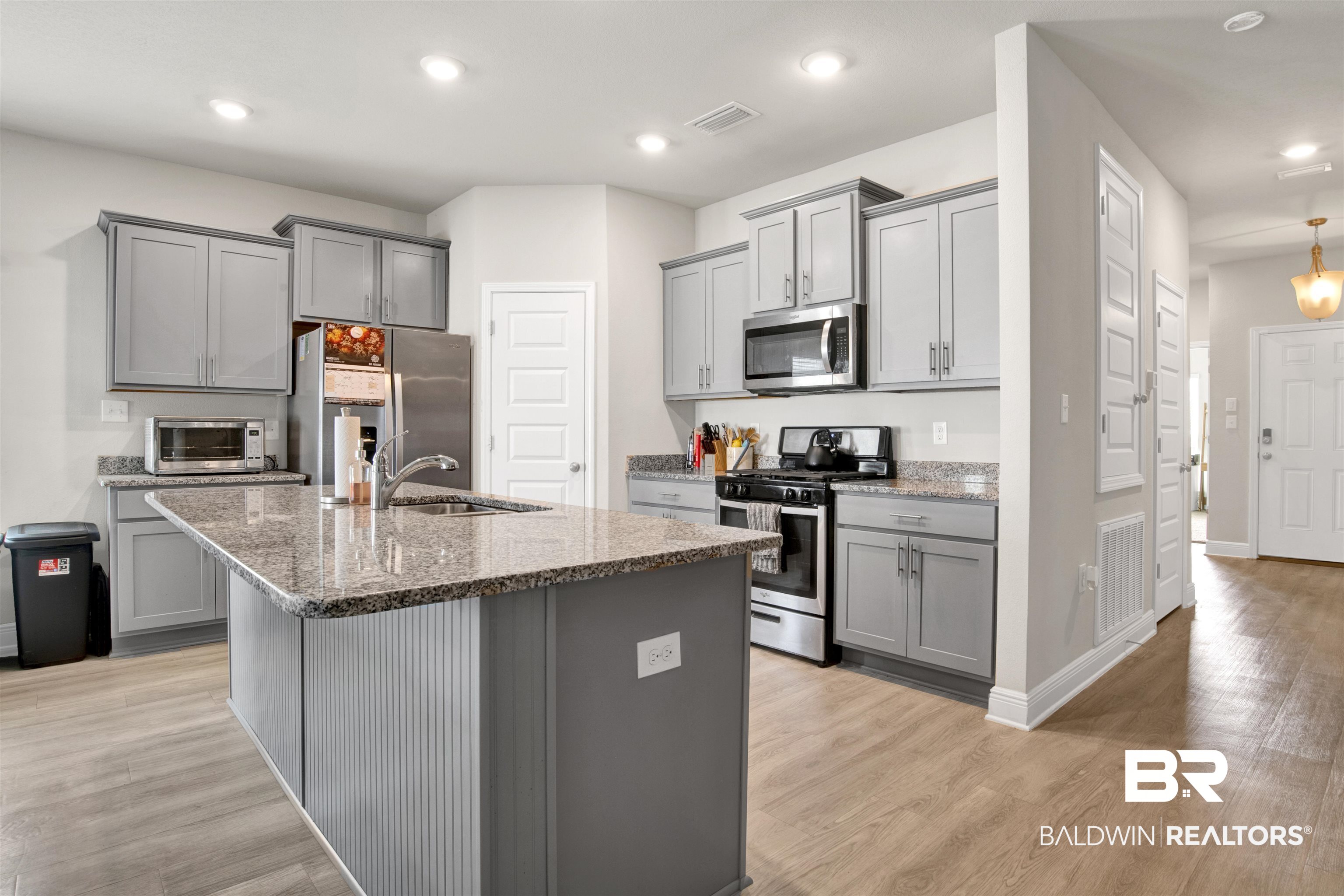 24253 Alydar Loop Daphne, AL 36526 - Photo 9 of 44 Kitchen with gray cabinets, stainless steel appliances, light stone counters, light wood-style flooring, and recessed lighting