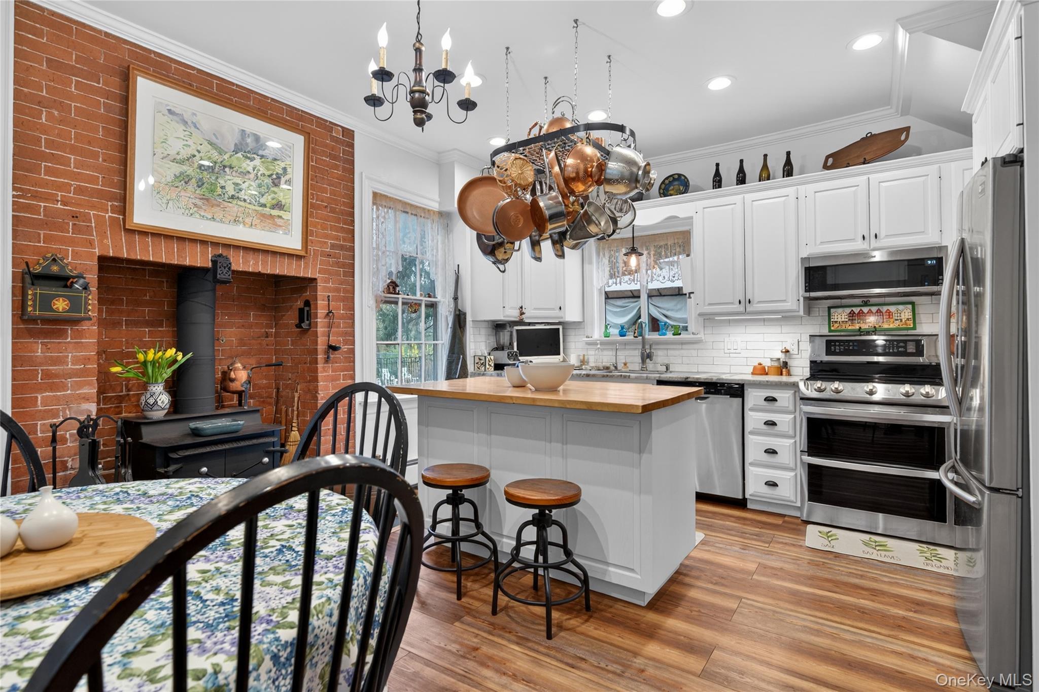 90 Quaker Avenue Cornwall, NY 12518 - Photo 17 of 50 a kitchen with stainless steel appliances granite countertop a stove top oven a sink a dining table and chairs with wooden floor