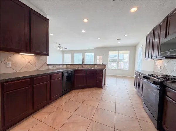 a kitchen with stainless steel appliances granite countertop a sink stove and cabinets