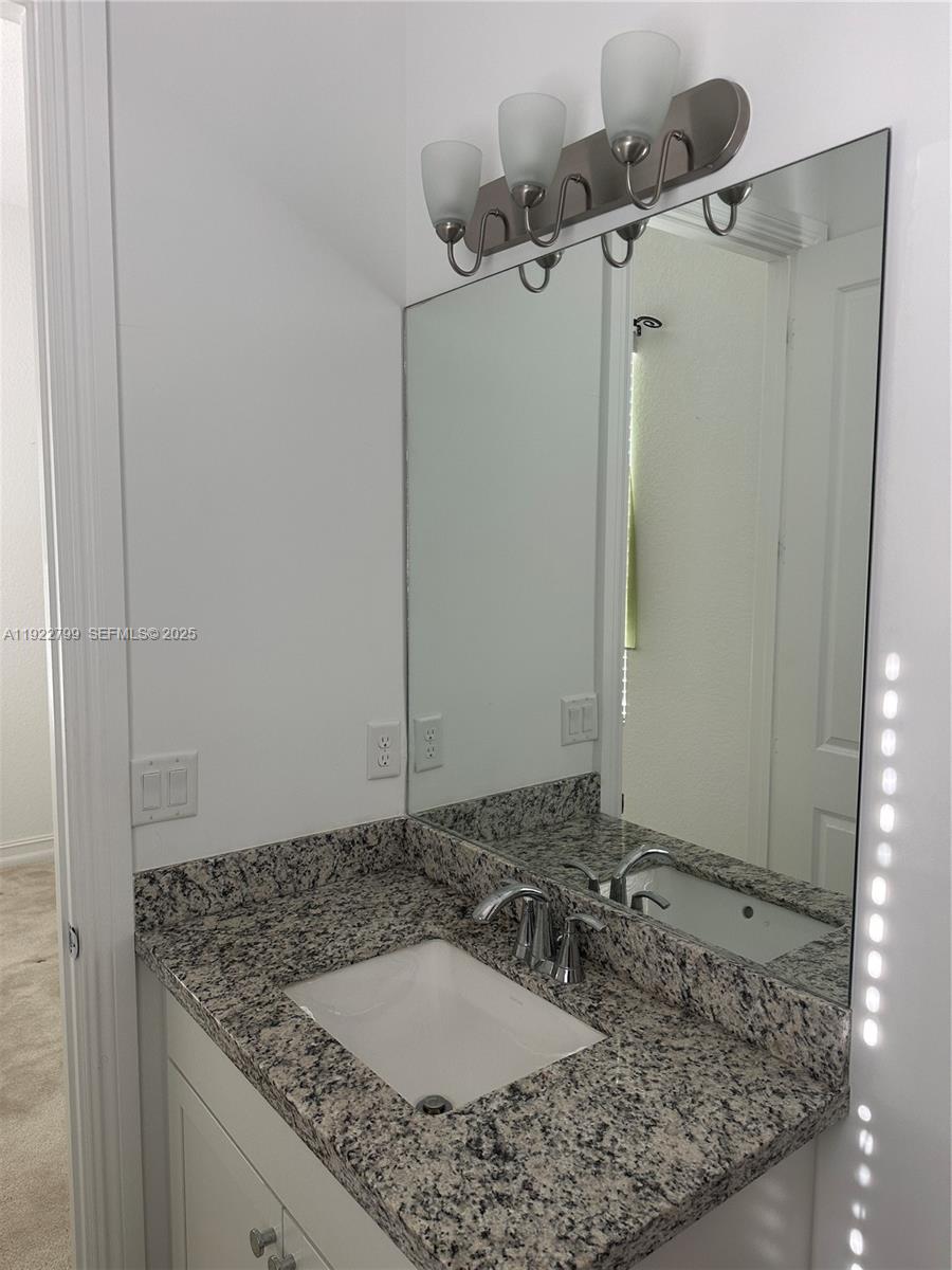 11718 Southwest 13th Ct. Pembroke Pines, FL 33025 - Photo 11 of 35 a bathroom with a granite countertop sink and a mirror
