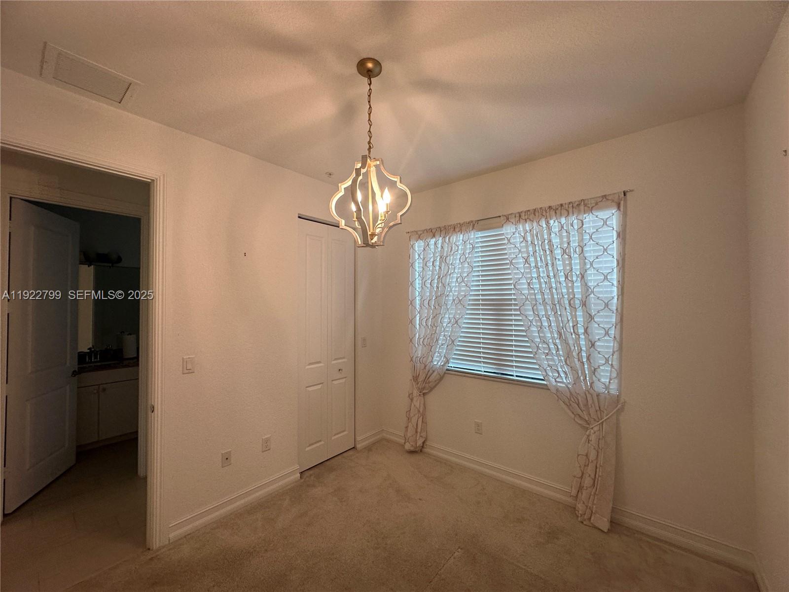 11718 Southwest 13th Ct. Pembroke Pines, FL 33025 - Photo 18 of 35 an empty room with chandelier fan and windows