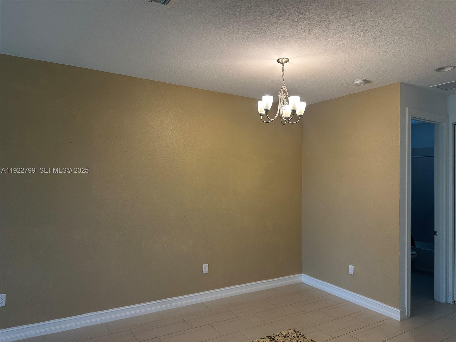 11718 Southwest 13th Ct. Pembroke Pines, FL 33025 - Photo 20 of 35 en empty room with a chandelier fan and a window