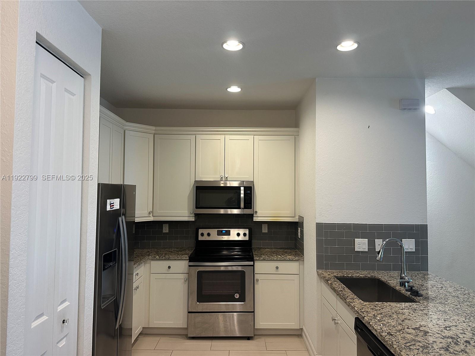 11718 Southwest 13th Ct. Pembroke Pines, FL 33025 - Photo 23 of 35 a kitchen with granite countertop stainless steel appliances and wooden cabinets