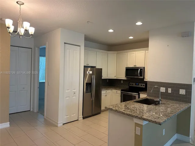 a view of a kitchen with a sink and refrigerator