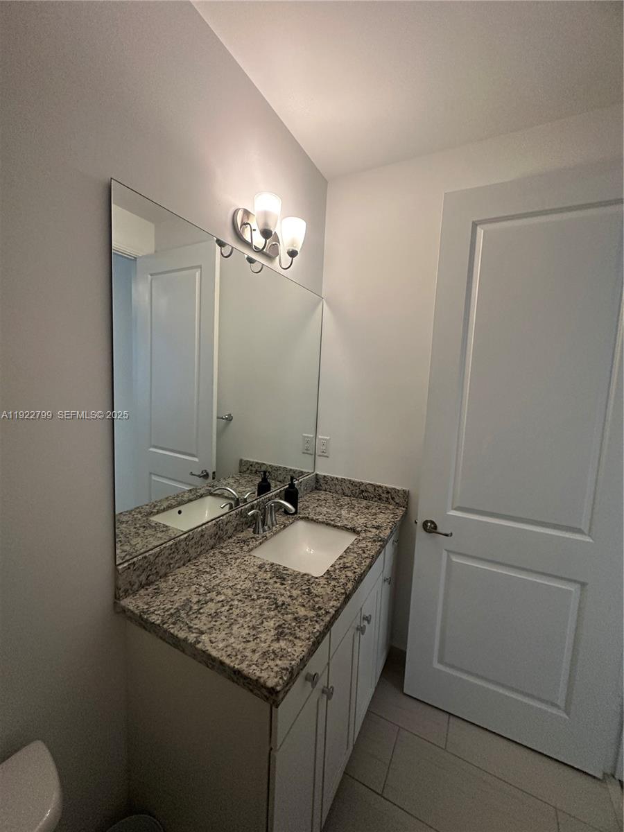11718 Southwest 13th Ct. Pembroke Pines, FL 33025 - Photo 27 of 35 a bathroom with a granite countertop sink and a mirror