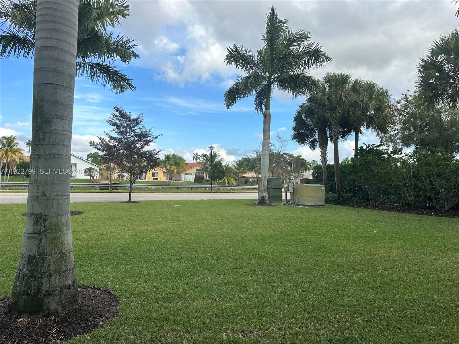 11718 Southwest 13th Ct. Pembroke Pines, FL 33025 - Photo 4 of 35 a view of a field of grass and palm trees