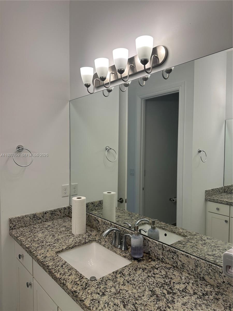 11718 Southwest 13th Ct. Pembroke Pines, FL 33025 - Photo 5 of 35 a bathroom with a granite countertop sink a toilet and mirror