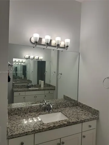 a bathroom with a granite countertop shower and a sink
