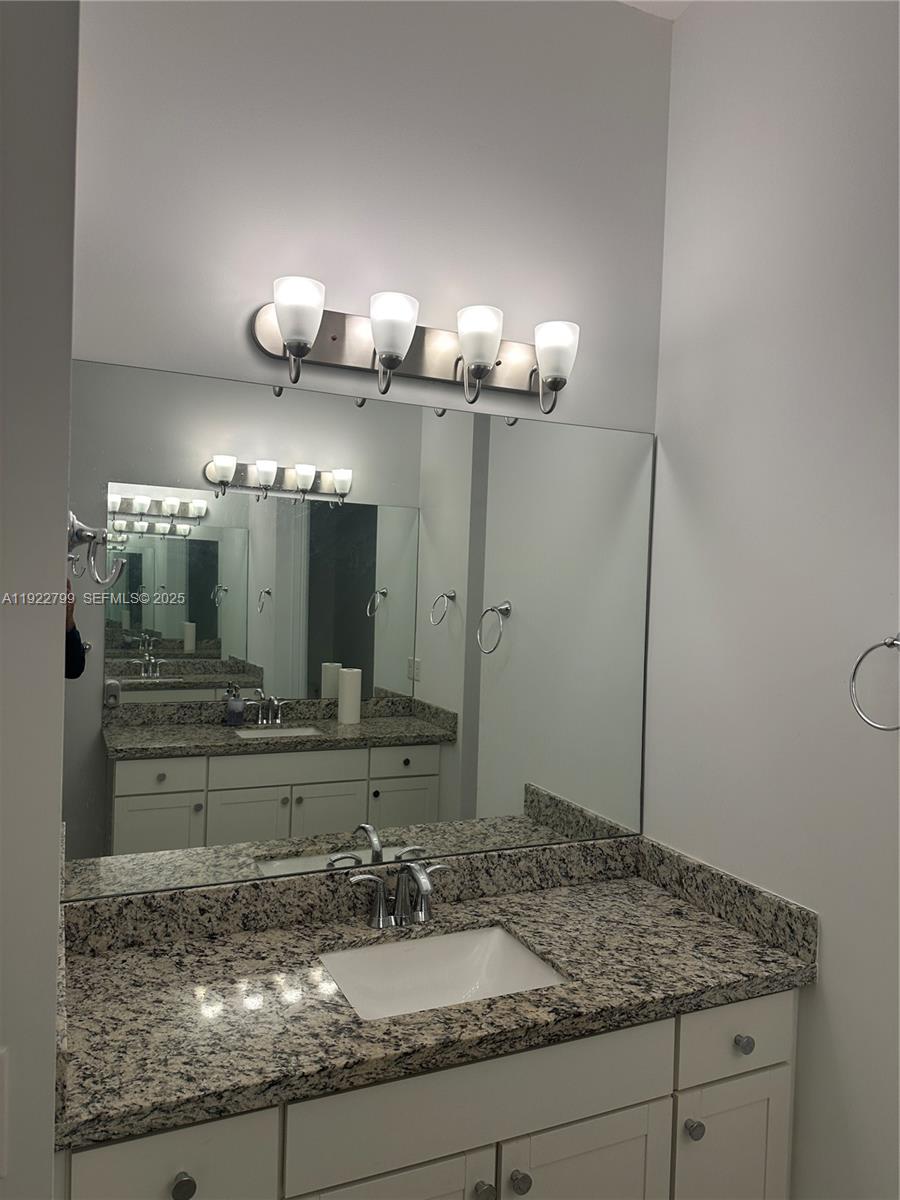 11718 Southwest 13th Ct. Pembroke Pines, FL 33025 - Photo 6 of 35 a bathroom with a granite countertop sink and a mirror