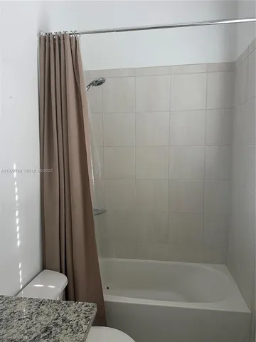 an empty room with chandelier fan and windows