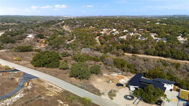an aerial view of a house with a yard and lake view