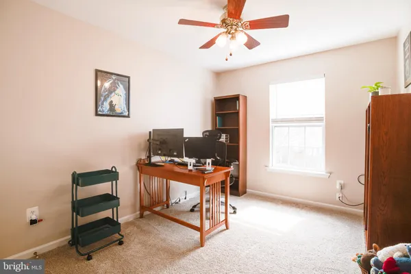 a view of a workspace with furniture and a window