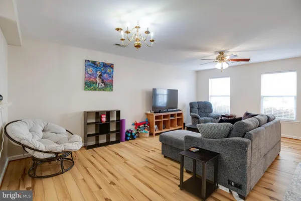a living room with furniture a fireplace and a chandelier