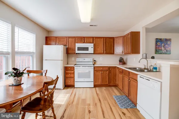 a kitchen with a sink appliances a counter space and a window