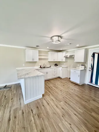 a large kitchen with a wooden floor and cabinets