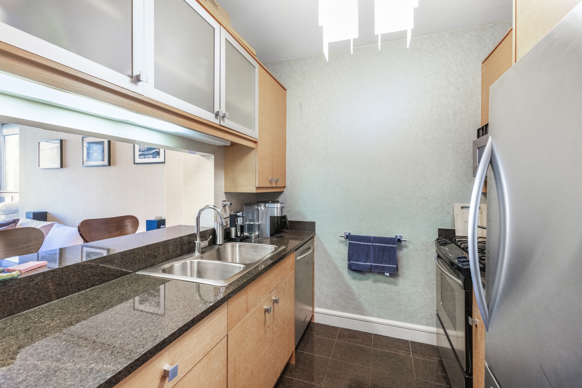 120 Riverside Boulevard, Unit 14C Manhattan, NY 10069 - Photo 9 of 11 a kitchen with stainless steel appliances granite countertop a sink and a refrigerator