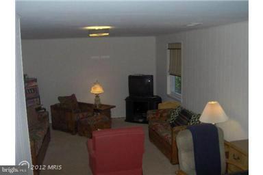 6307 Brooklyn Bridge Road Laurel, MD 20707 - Photo 5 of 17 a living room with furniture a lamp and a flat screen tv