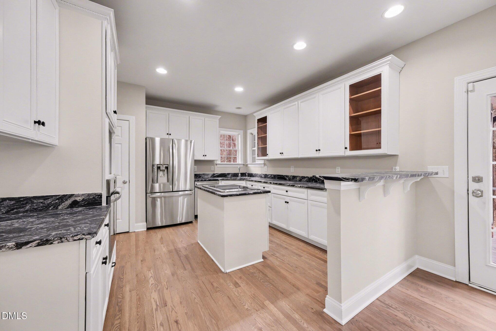 4613 Cherrybark Lane Raleigh, NC 27616 - Photo 7 of 27 a kitchen with white cabinets and stainless steel appliances