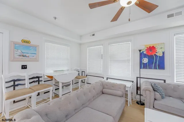 a living room with furniture kitchen view and a chandelier