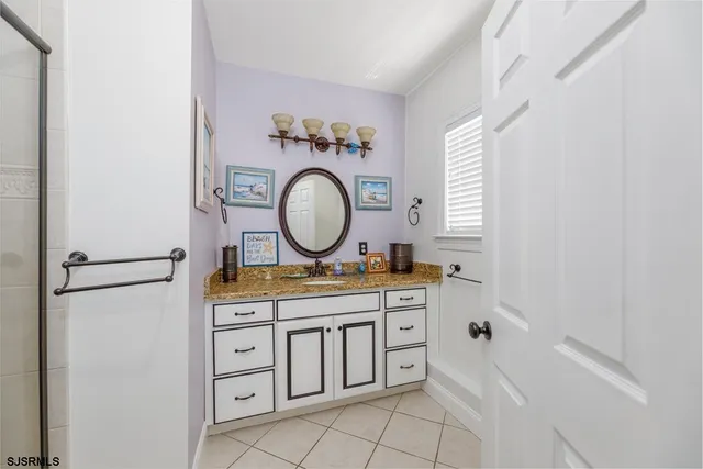 a hall with kitchen island a sink a stove and a clock on the wall