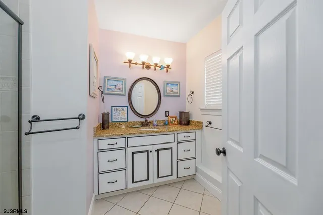 a bathroom with a granite countertop double vanity sink a mirror and a