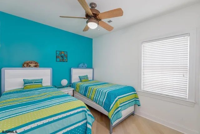 a bedroom with a bed and a flat tv screen on dresser