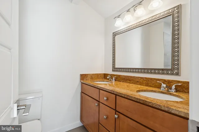 a bathroom with a granite countertop sink and a mirror